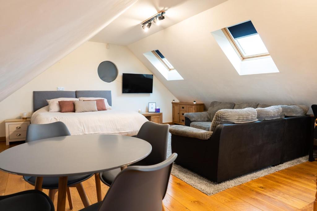 - une chambre avec un lit, une table et un canapé dans l'établissement Silverwood Loft, à Telford