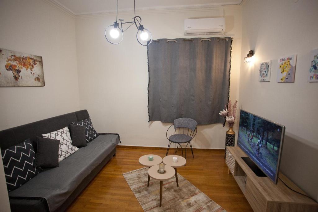 a living room with a couch and a tv at Lovely Nest Piraeus in Piraeus