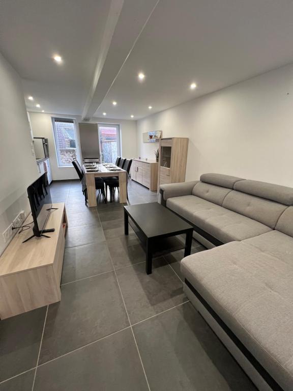 salon z kanapą i stołem w obiekcie maison centre de cassel w mieście Cassel