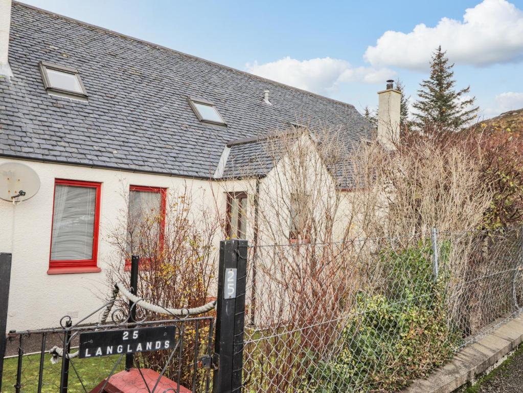 une maison blanche avec une clôture devant elle dans l'établissement 25 Langlands Terrace, à Kyle of Lochalsh