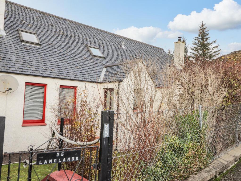 a white house with a fence in front of it at 25 Langlands Terrace in Kyle of Lochalsh