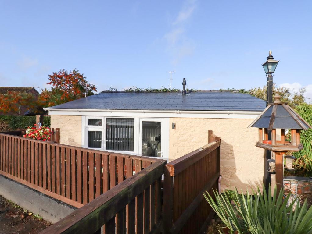 a home with a wooden fence and a house at The Park Inn Piggery in Newton Abbot