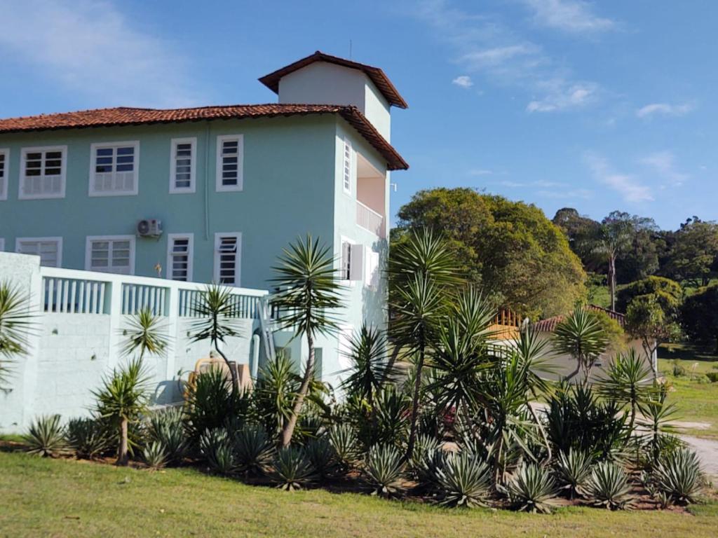 une maison blanche avec des palmiers devant elle dans l'établissement Pousada Macanaíba, 