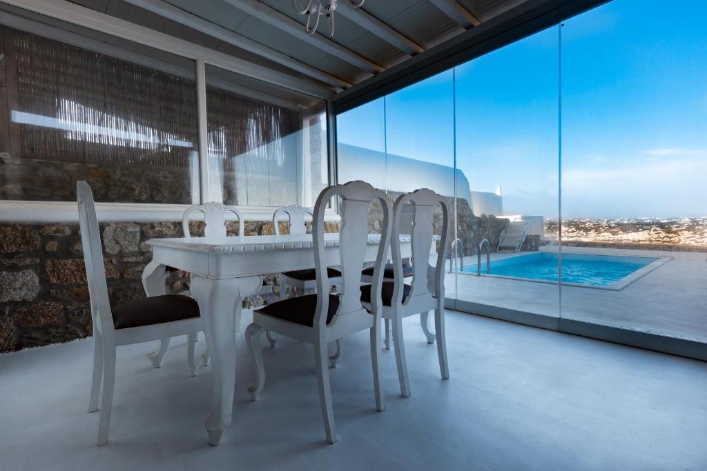 a white dining room with a table and chairs at Admiralty House in Agios Ioannis Mykonos