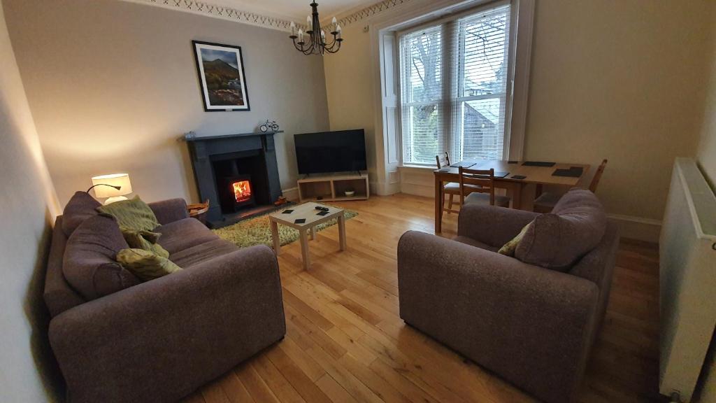 a living room with two couches and a fireplace at Lovely property in Central Broughty Ferry, Dundee in Broughty Ferry