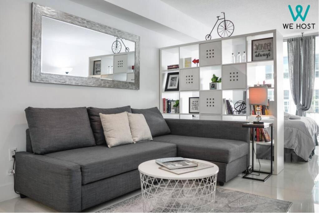 uma sala de estar com um sofá cinzento e um espelho em Fascinating Studio Apt at Brickell em Miami