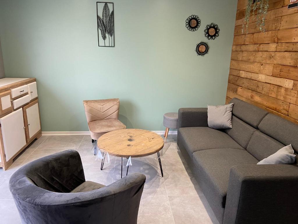 un salon avec un canapé, des chaises et une table dans l'établissement Gîtes 6A et 6B, à Bailleul-Sir-Berthoult