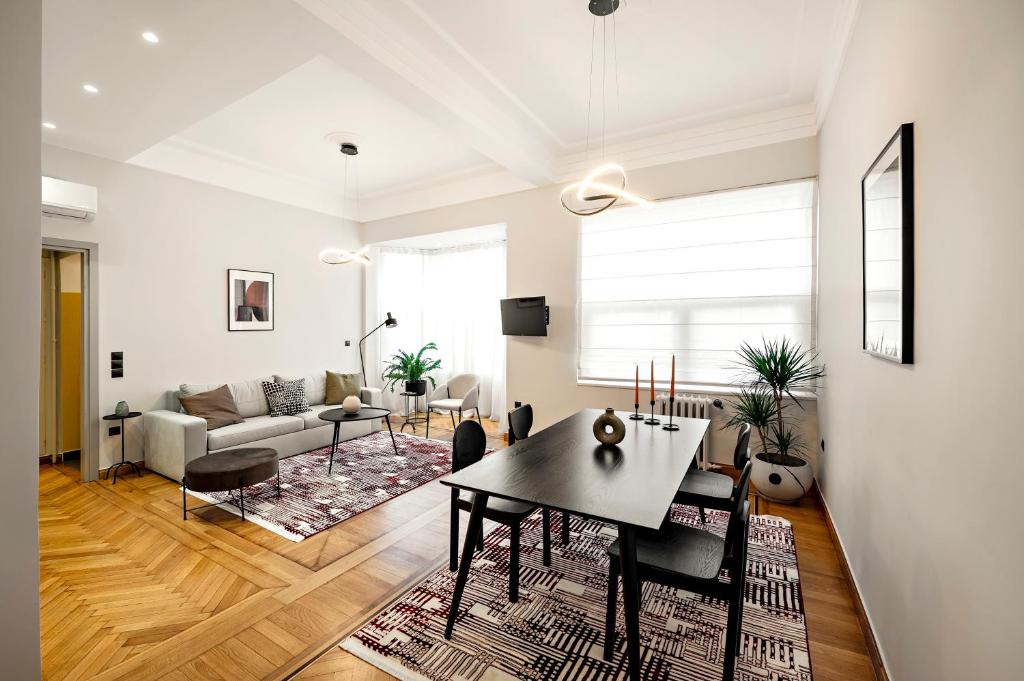 uma sala de estar com uma mesa e um sofá em JUST KOLONAKI em Atenas