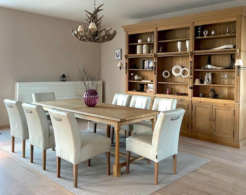 comedor con mesa de madera y sillas blancas en Luxe penthouse center Kortrijk, en Cortrique