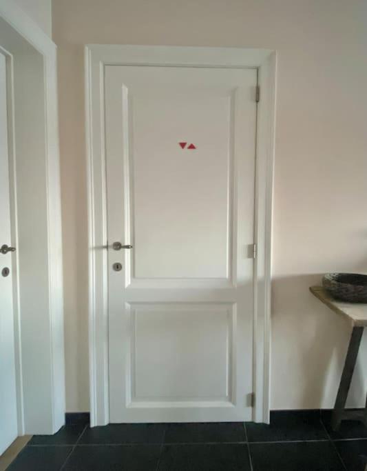 a white door in a room with a table at Luxe penthouse center Kortrijk in Kortrijk