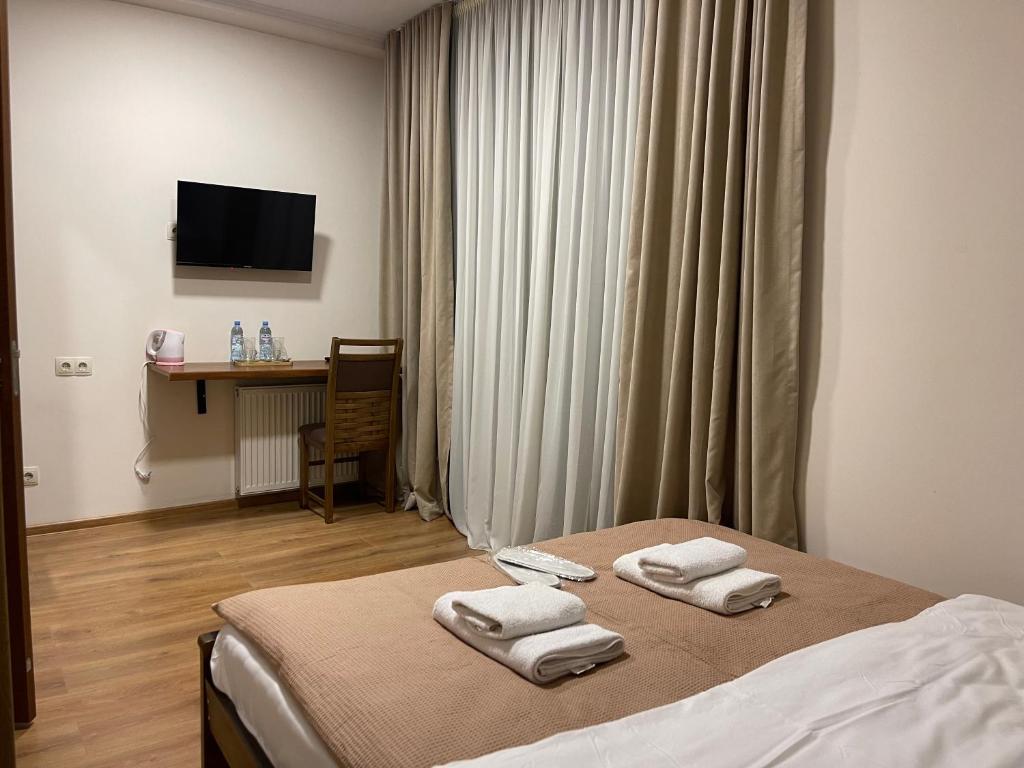 een hotelkamer met een bed met handdoeken erop bij ART family hotel in Tbilisi City