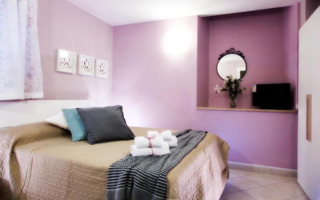 ローマにあるLa Chiostrinaの紫の壁のベッドルーム1室、ベッド1台(タオル付)が備わります。
