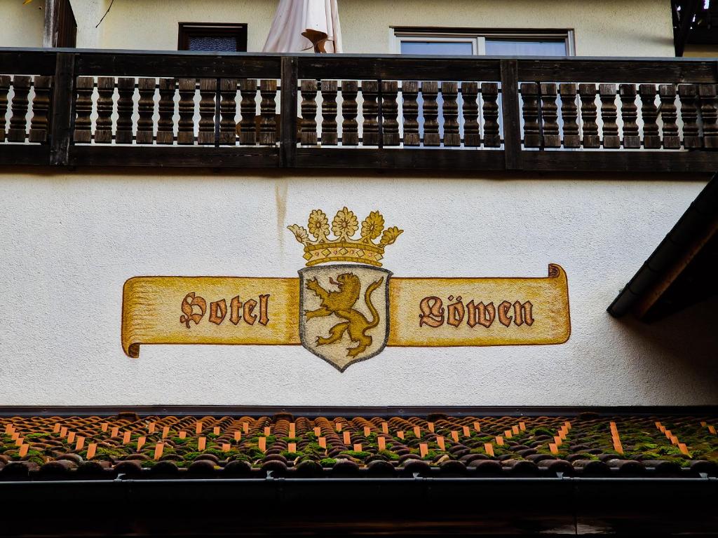 ein Schild an der Seite eines Gebäudes mit einer Krone in der Unterkunft Hostel zum Löwen in Todtmoos