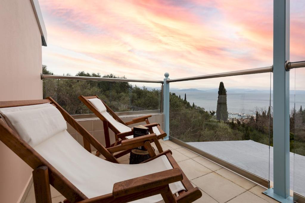 balkon z 2 krzesłami i widokiem na ocean w obiekcie Villa Olive Tree by Estia w mieście Benitses