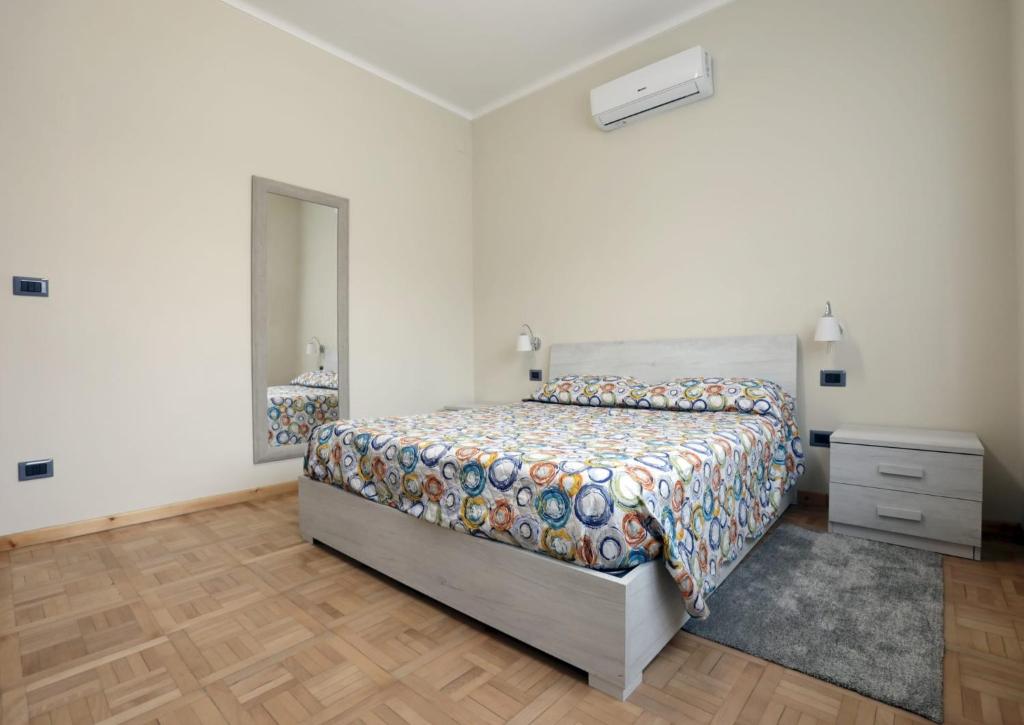1 dormitorio con cama, tocador y espejo en Langhe Apartament, en Monforte dʼAlba