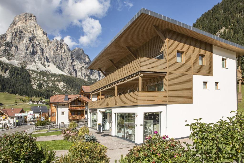 a building with a mountain in the background at Ciasa Vilin in Corvara in Badia