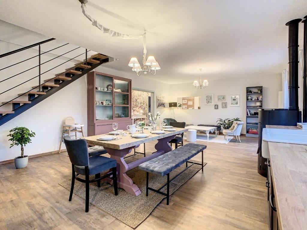 uma sala de jantar com mesa e cadeiras em Aux Magnolias, Maison proche Colmar et Munster em Zimmerbach