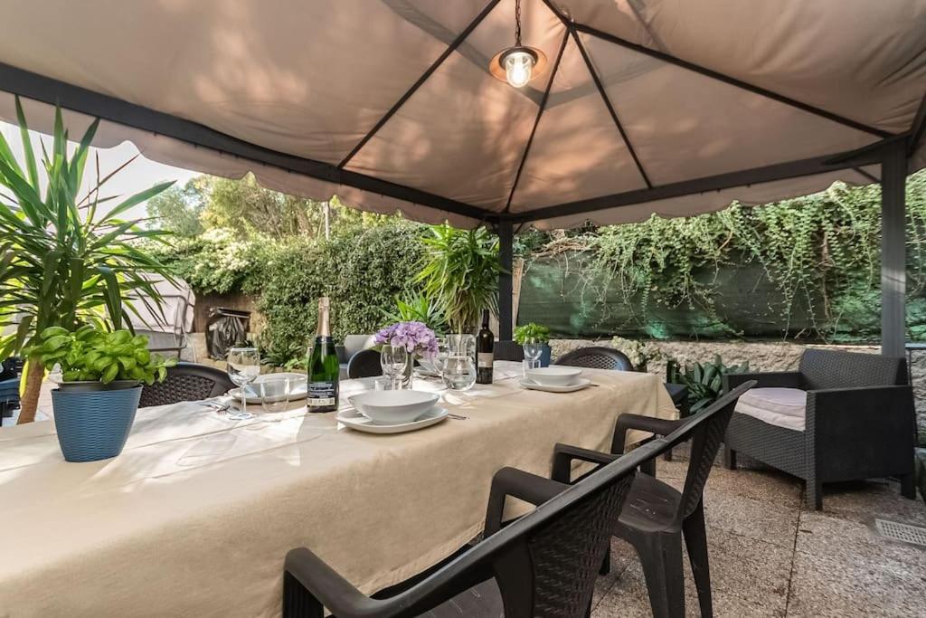 Genova Garden, vicino al Gaslini e Boccadasse في جينوا: طاولة مع كراسي ومظلة كبيرة
