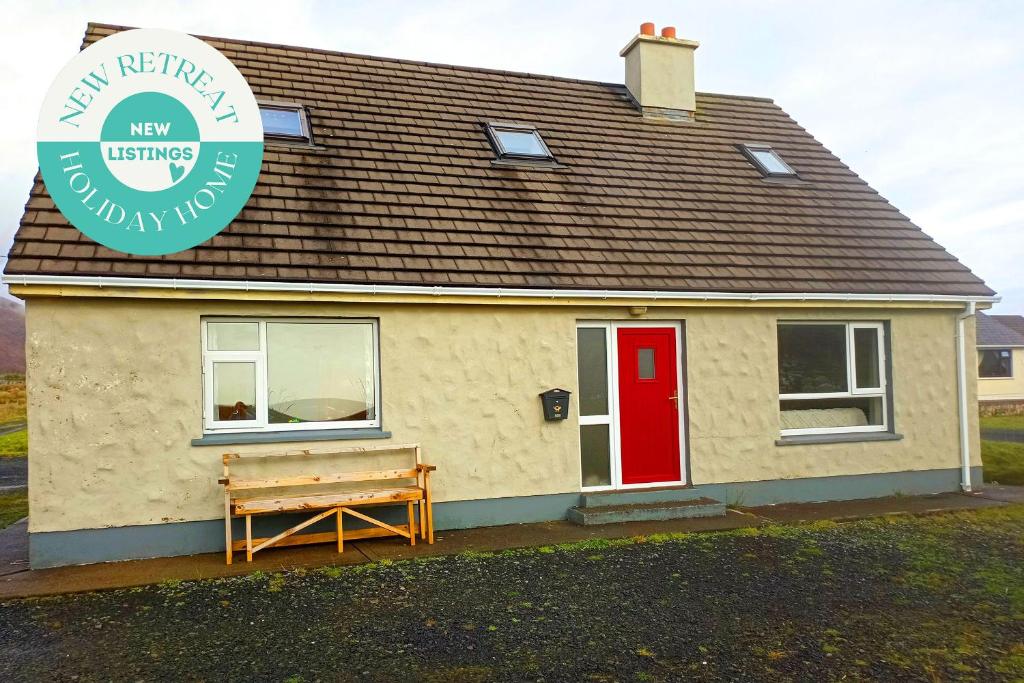 a small house with a red door and a bench at Sarlyn Holiday Home Achill in River