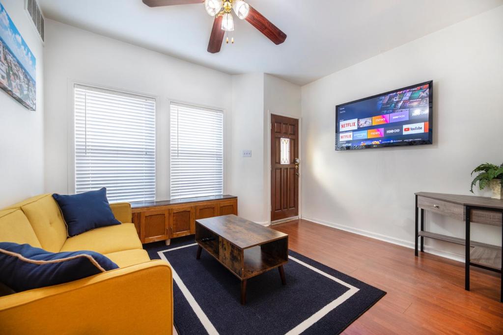 a living room with a couch and a tv at Charming mini-suite in West Campus! in Austin