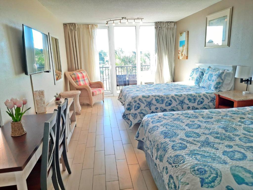 Habitación de hotel con 2 camas y balcón en Lovely Sandestin Resort Studio with Balcony and Sunset View en Destin