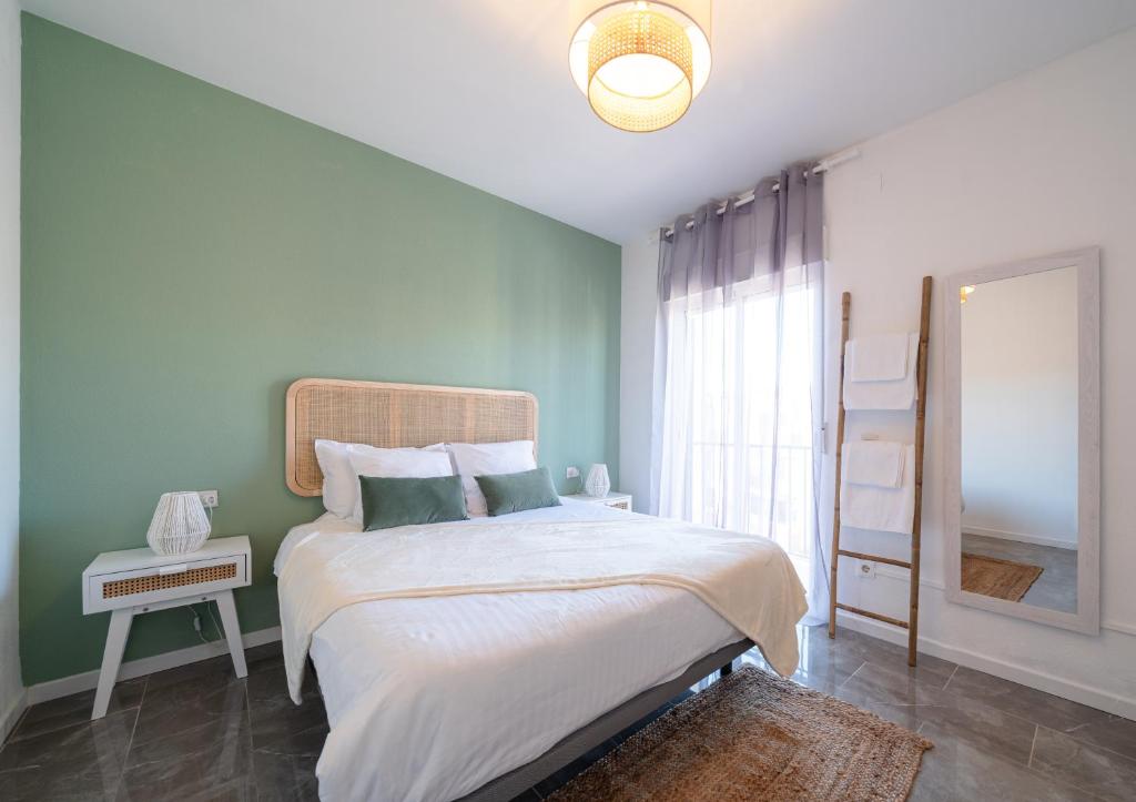 een slaapkamer met een groot bed en een spiegel bij Bonito apartamento equipado, cerca de la playa in Empuriabrava