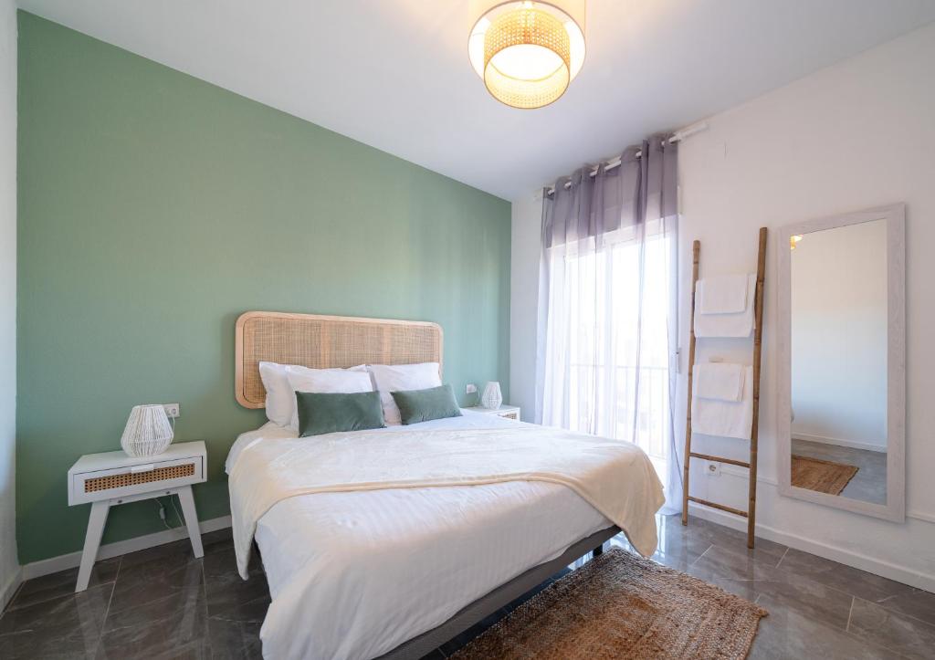 a bedroom with a large bed and a mirror at Bonito apartamento equipado, cerca de la playa in Empuriabrava