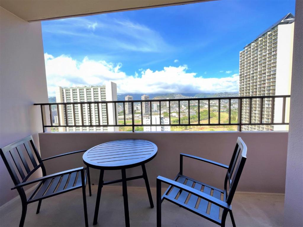 a table and chairs on a balcony with a view at Royal Kuhio 2304 - Spacious Studio with Stunning Mountain Views In the Heart of Waikiki! in Honolulu