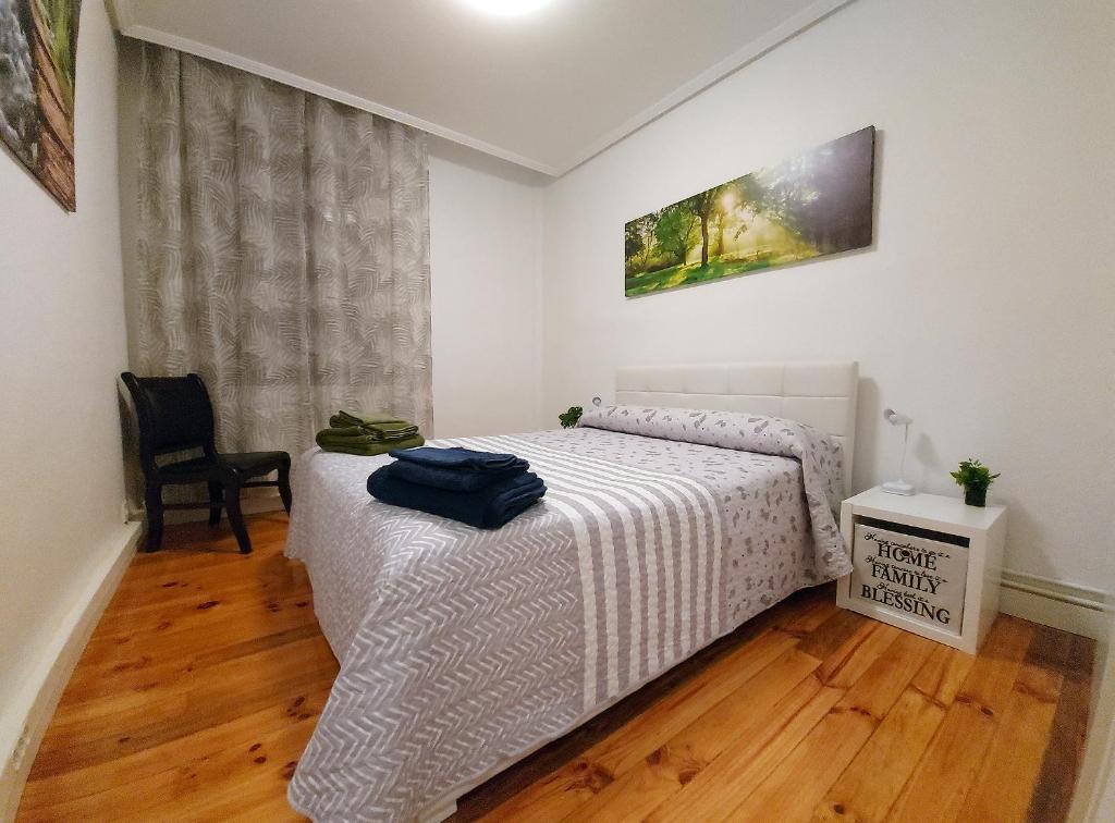 sypialnia z łóżkiem i krzesłem w obiekcie Apartamento Saioa w Pampelunie