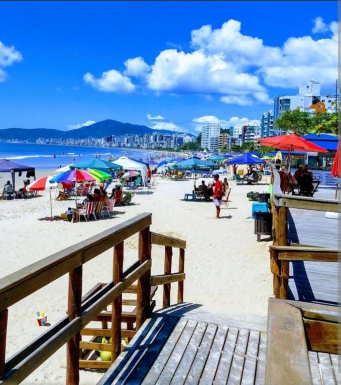 a beach with umbrellas and people on the sand at Apto temporada Itapema sc in Itapema
