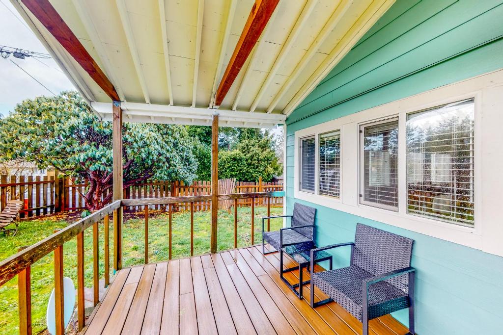 a screened porch with two chairs on a deck at Bungalow by the Bay in Netarts
