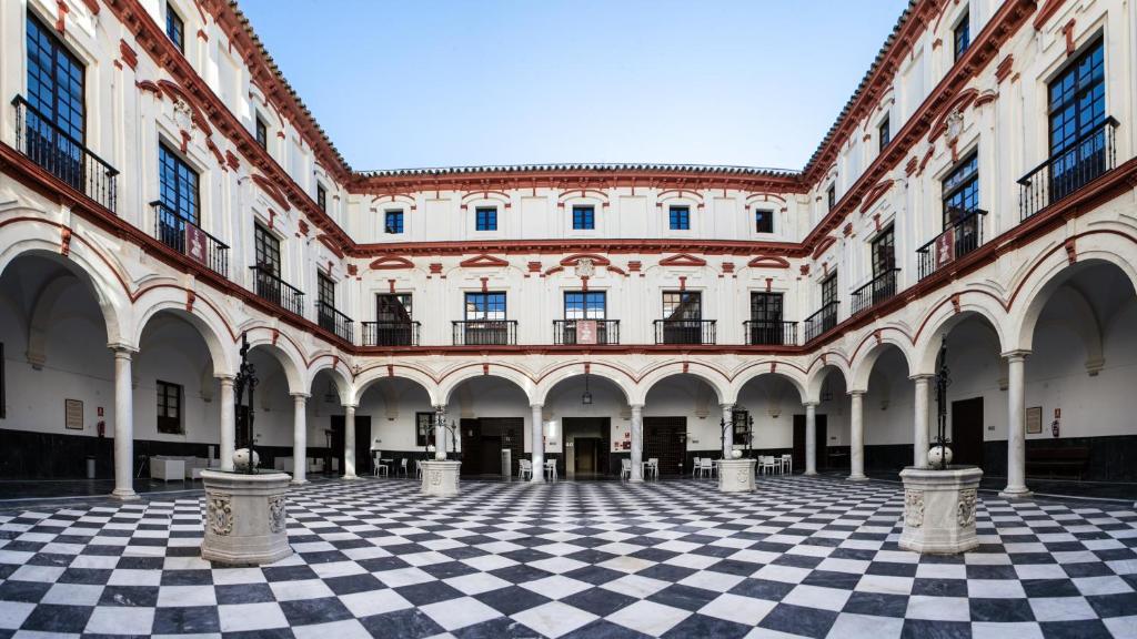 un cortile vuoto di un edificio con pavimento a scacchi di Hotel Boutique Convento Cádiz a Cadice