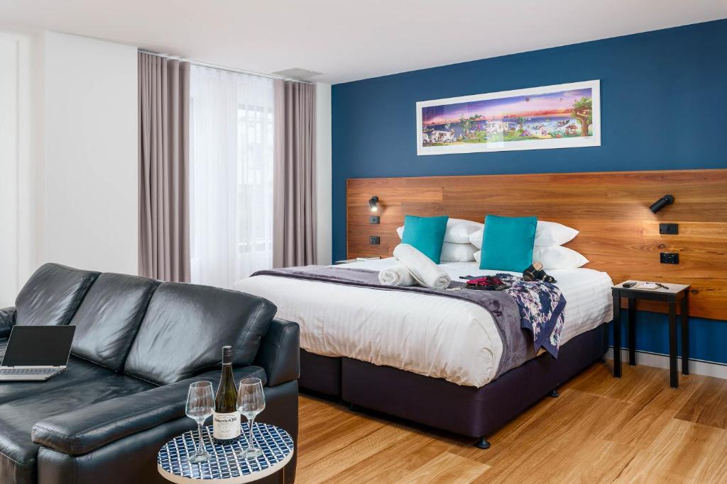 um quarto de hotel com uma cama e um sofá em Hunter Studios - Maitland em Maitland