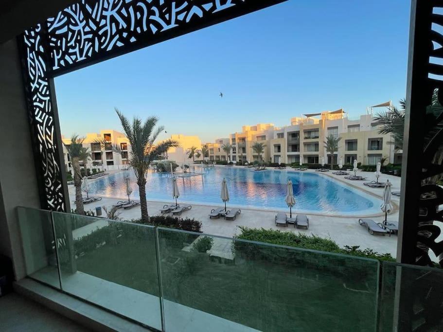 a view of a swimming pool from a balcony of a hotel at Lovely 2-bedroom apartment with pool view in Hurghada