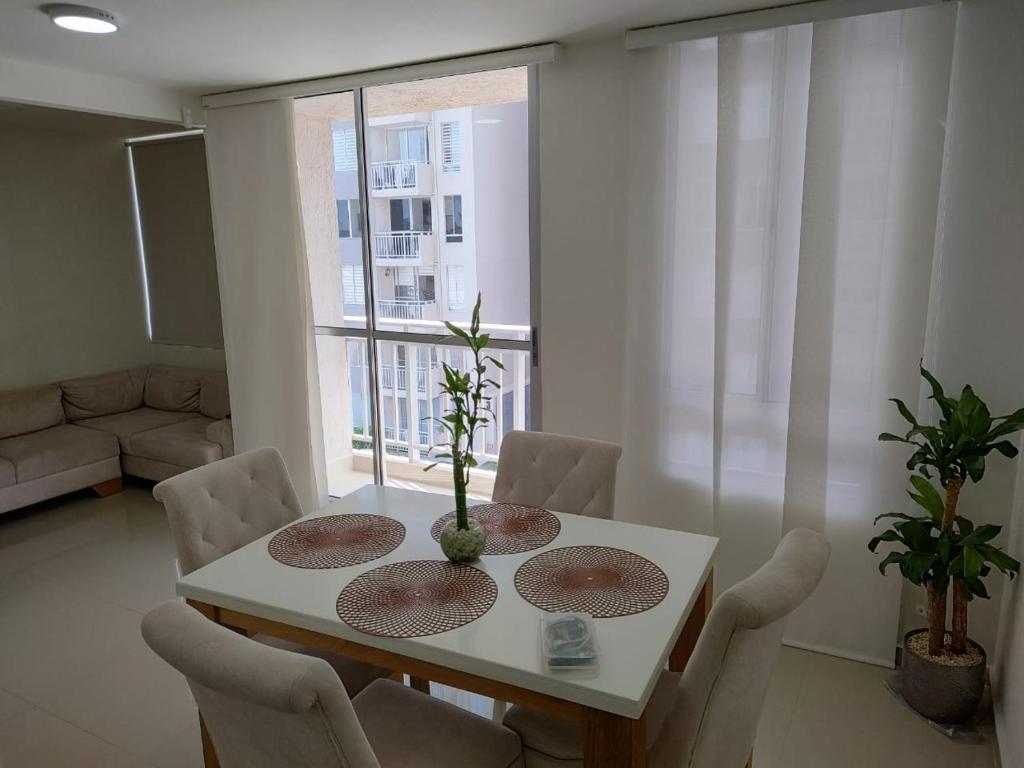 uma sala de jantar com uma mesa e cadeiras e uma janela em Apartamento Amoblado em Barranquilla