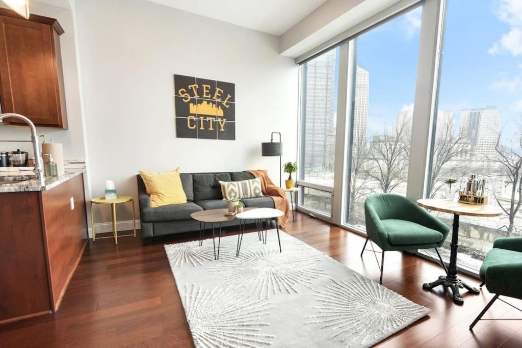 a living room with a couch and a large window at HostWise Stays - The Washington at Chatham - Free Parking, Private Gym, Skyline Views! in Pittsburgh