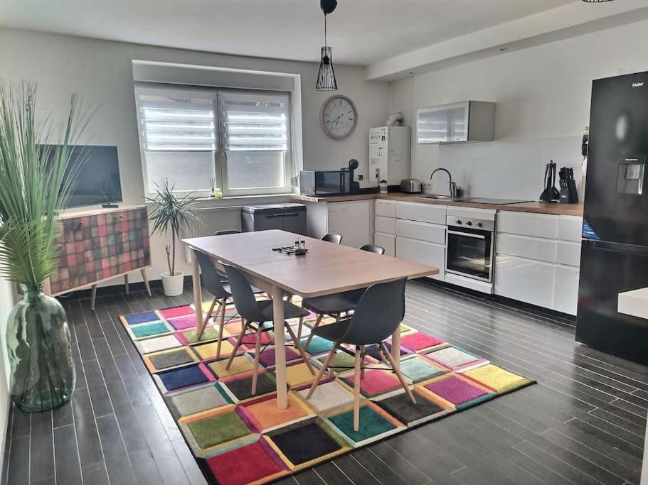 une cuisine avec une table et des chaises sur un tapis dans l'établissement Maison spacieuse 240m² - 7chambres - 16pers', à Woippy