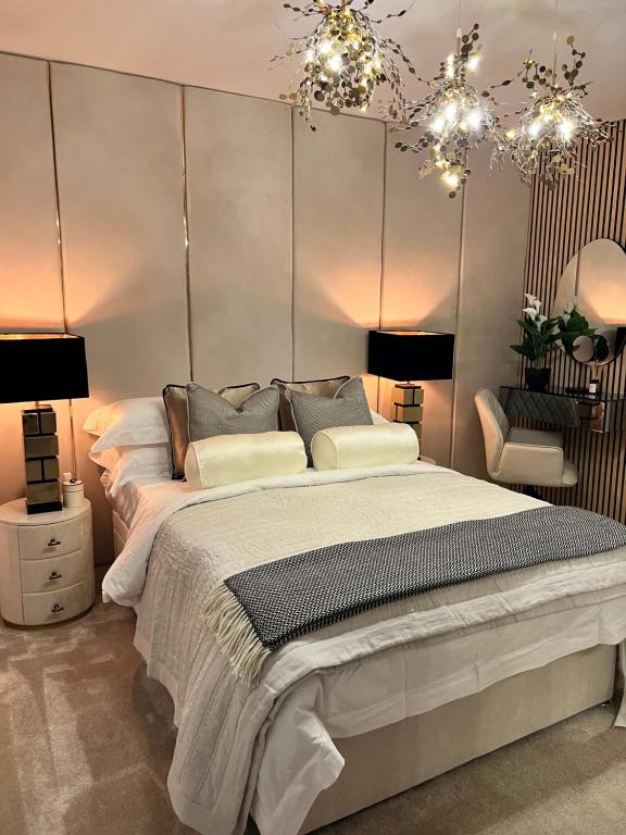 a bedroom with a large bed with two lamps and a chair at Cozen in Stone Grove