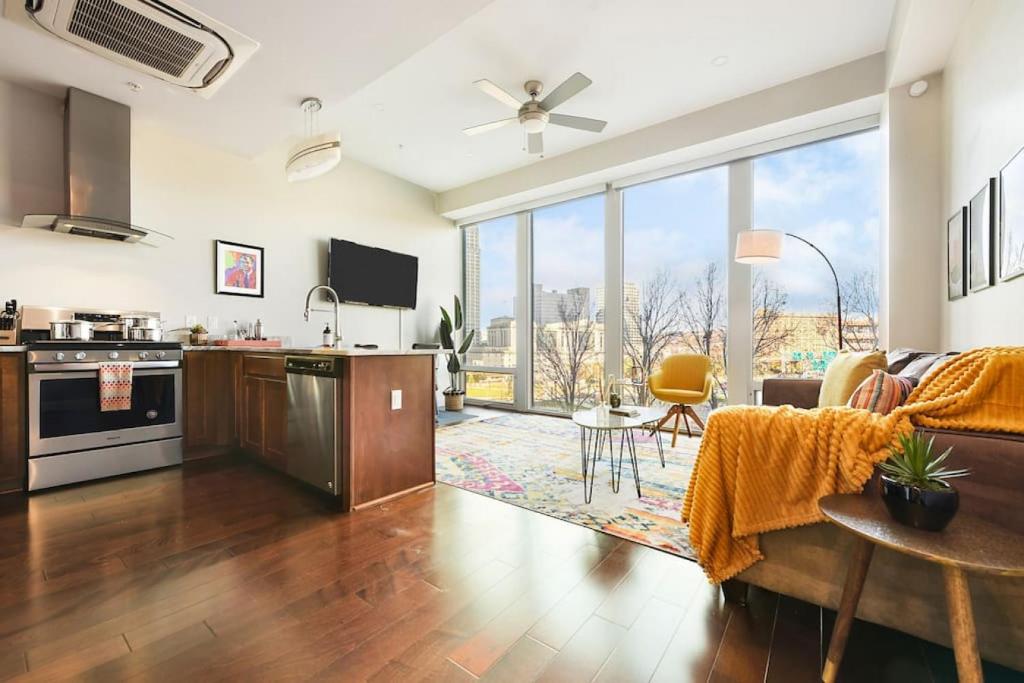 a kitchen and living room with a large window at HostWise Stays - The Washington at Chatham - Free Parking, Private Gym, Skyline Views! in Pittsburgh