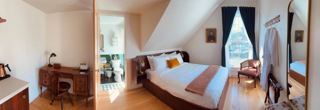 um quarto com uma cama grande e uma janela em Nicholson House at Beaujolais em Mendocino