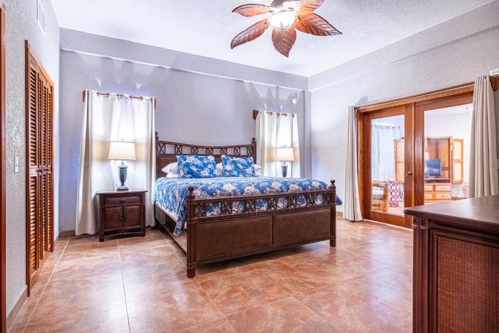 a bedroom with a bed and a ceiling fan at Lighthouse Beach Villas in San Pedro