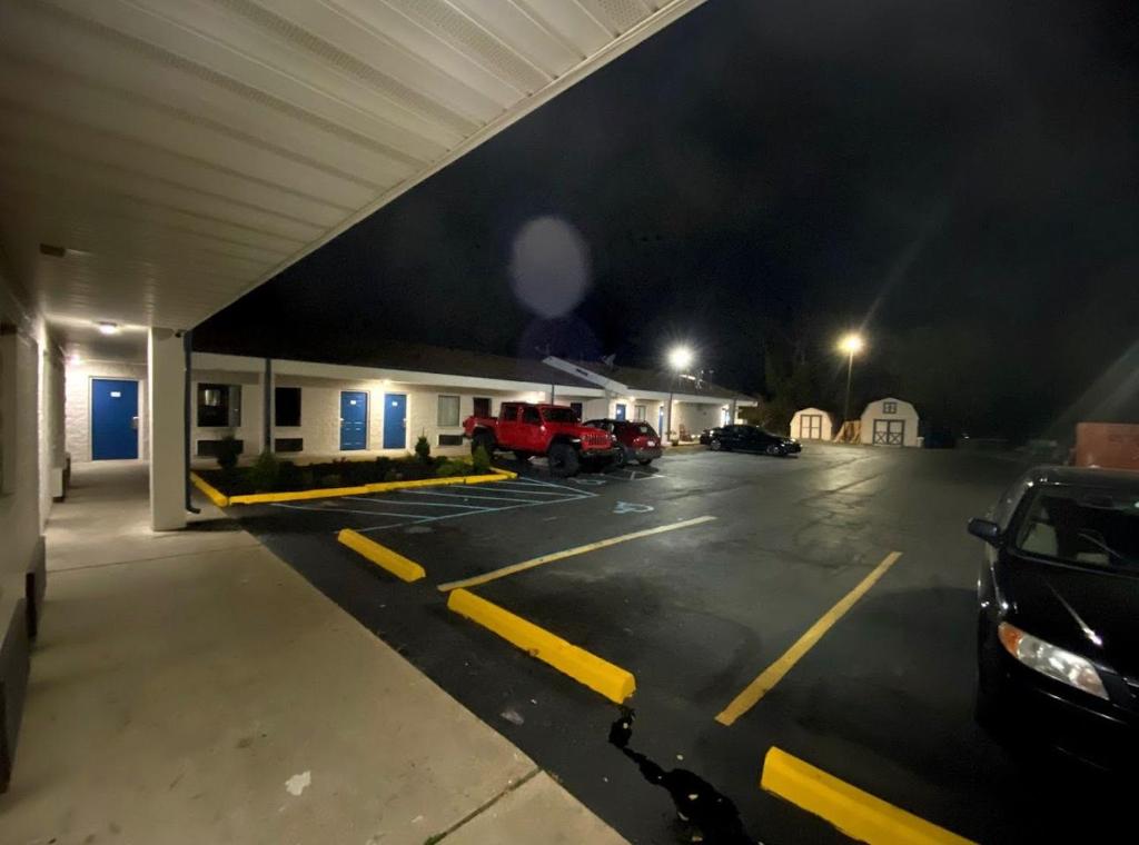 a parking lot with a car dealership at night at DELUXE INN in Erie