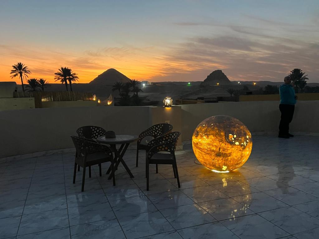 a table and chairs and a large ball on a patio at Sunset Guesthouse Abusir in Cairo