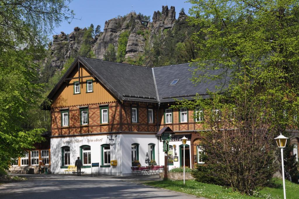 a large house with a mountain in the background at Hotel Gondelfahrt in Kurort Jonsdorf