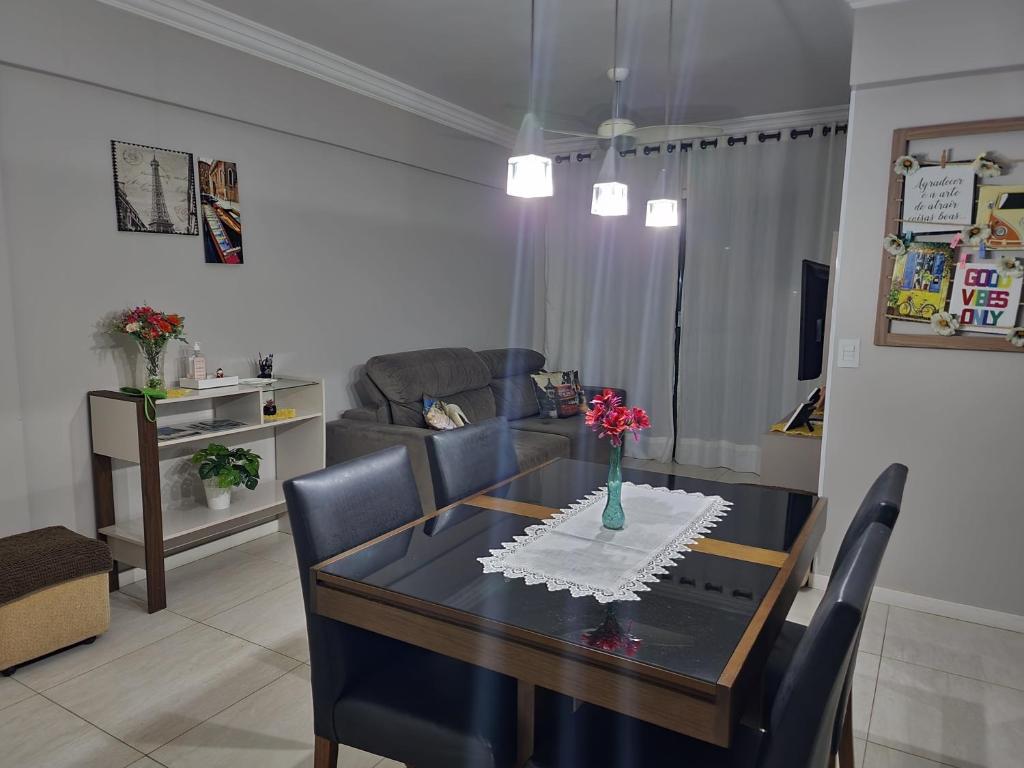 sala de estar con mesa de comedor y sofá en Apartamento Centro Bombinhas, en Bombinhas