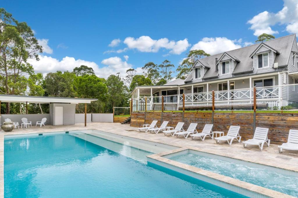 a house with a swimming pool in front of a house at The Estate Main House Byron Bay in Bangalow