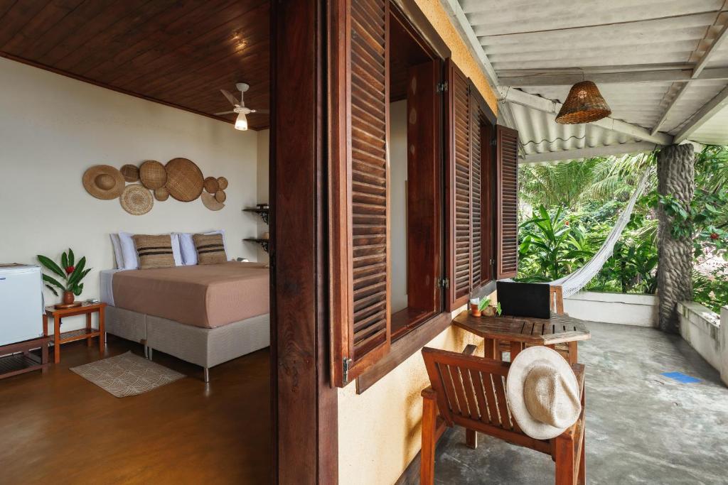 a bedroom with a bed and a desk with a table sidx sidx sidx at Pousada Pouso da Maré in Ilha de Boipeba