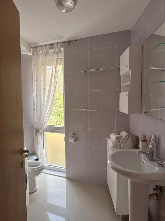 a bathroom with a sink and a toilet and a window at Apartman Floresta - In front of Japanese Garden, enchanting nature view, spotless and cozy in Vrnjačka Banja