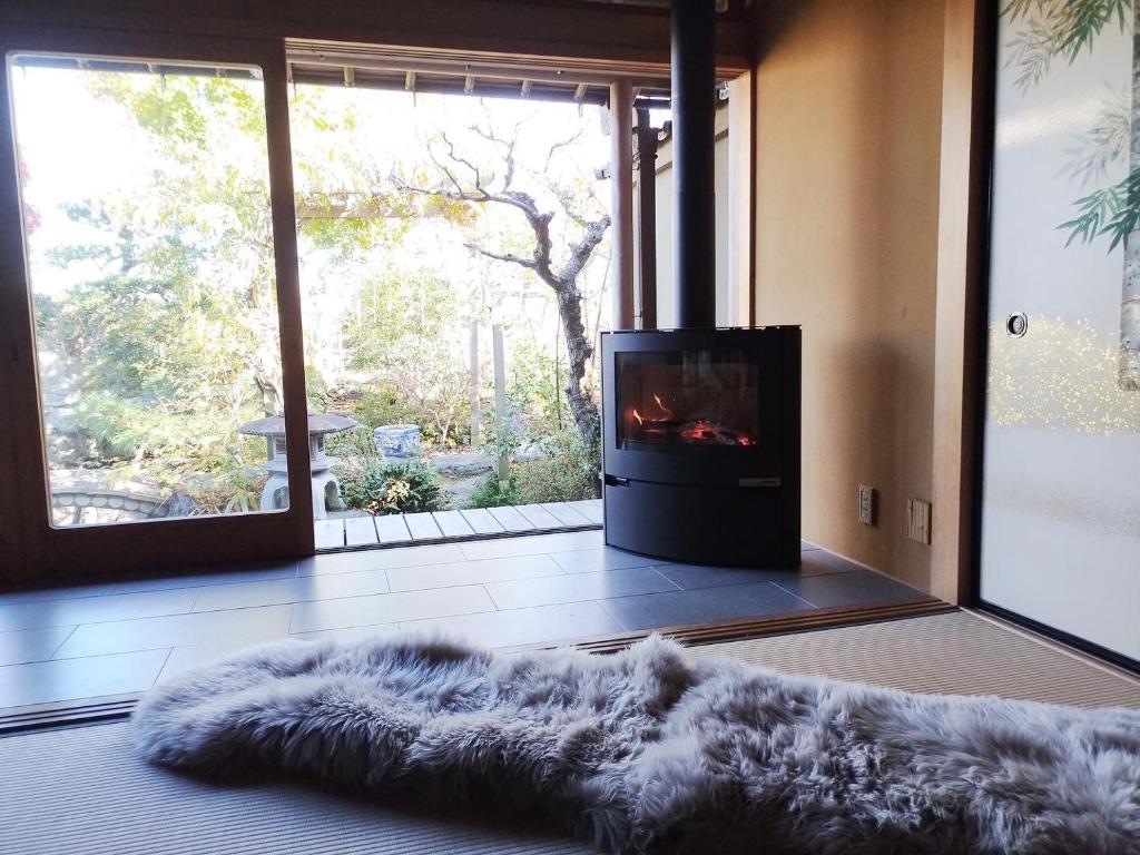 a living room with a fireplace and a television at Atelier Bee's Knees Bed & Breakfast in Ikuma