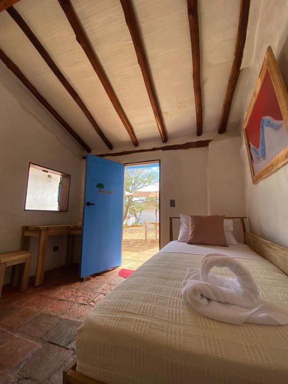 a bedroom with a bed in a room with a window at El Principito Hospedaje in Barichara